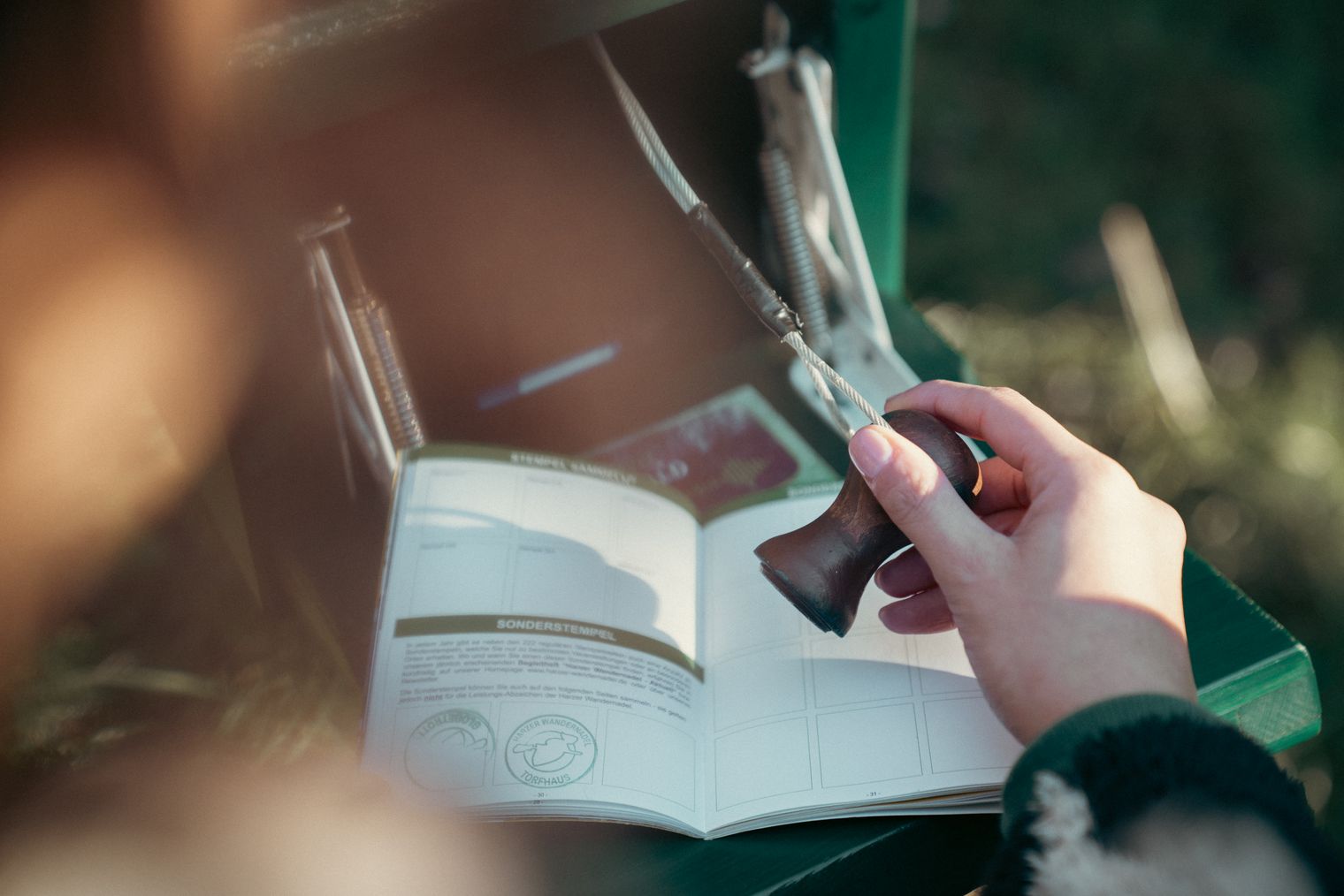 Hand stamps the Harz hiking pin in the hiking pass.
