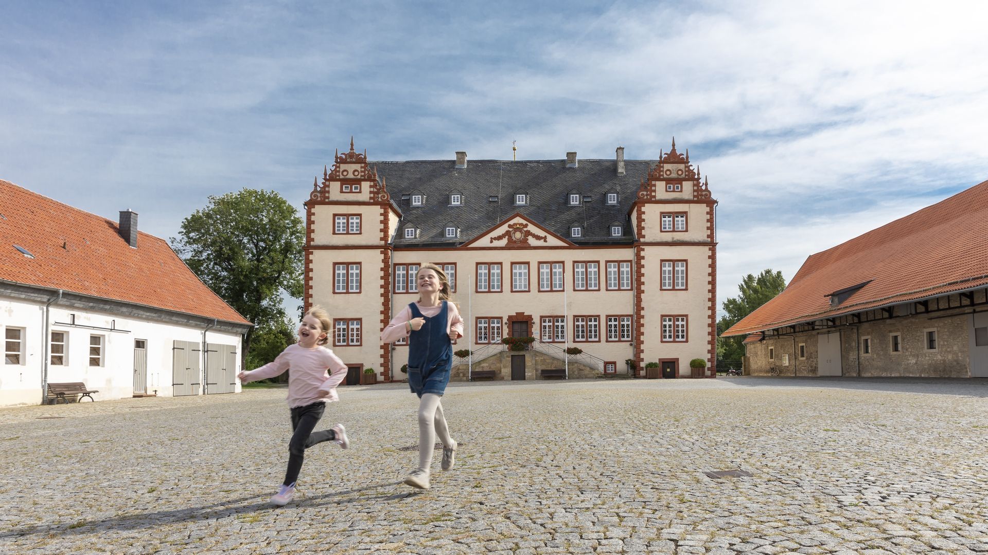Kinder laufen vor dem Schloss