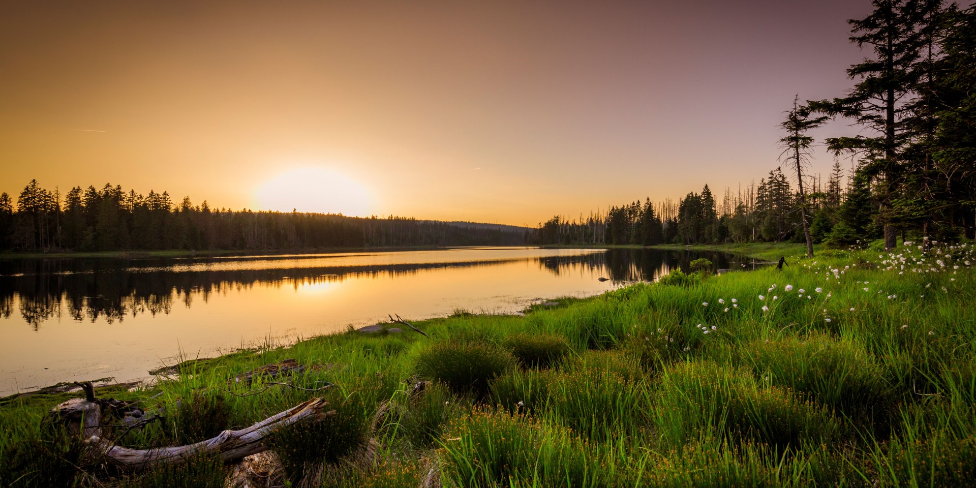 view of a lake as the sun rises in the mountainous Harz Mountains