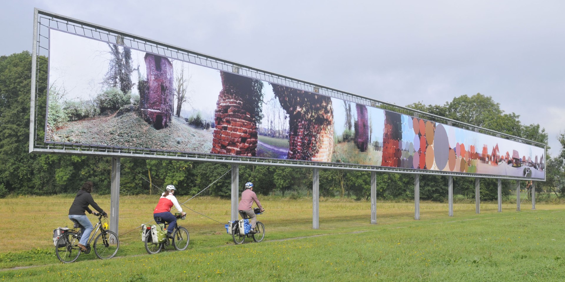 Three cyclists pass an art object, © TMN / Thorsten Brönner