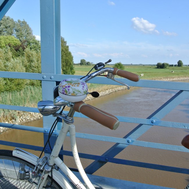 View from the Amdorf bridge in the foreground a bicycle, © Ostfriesland Tourismus GmbH / www.ostfriesland.de