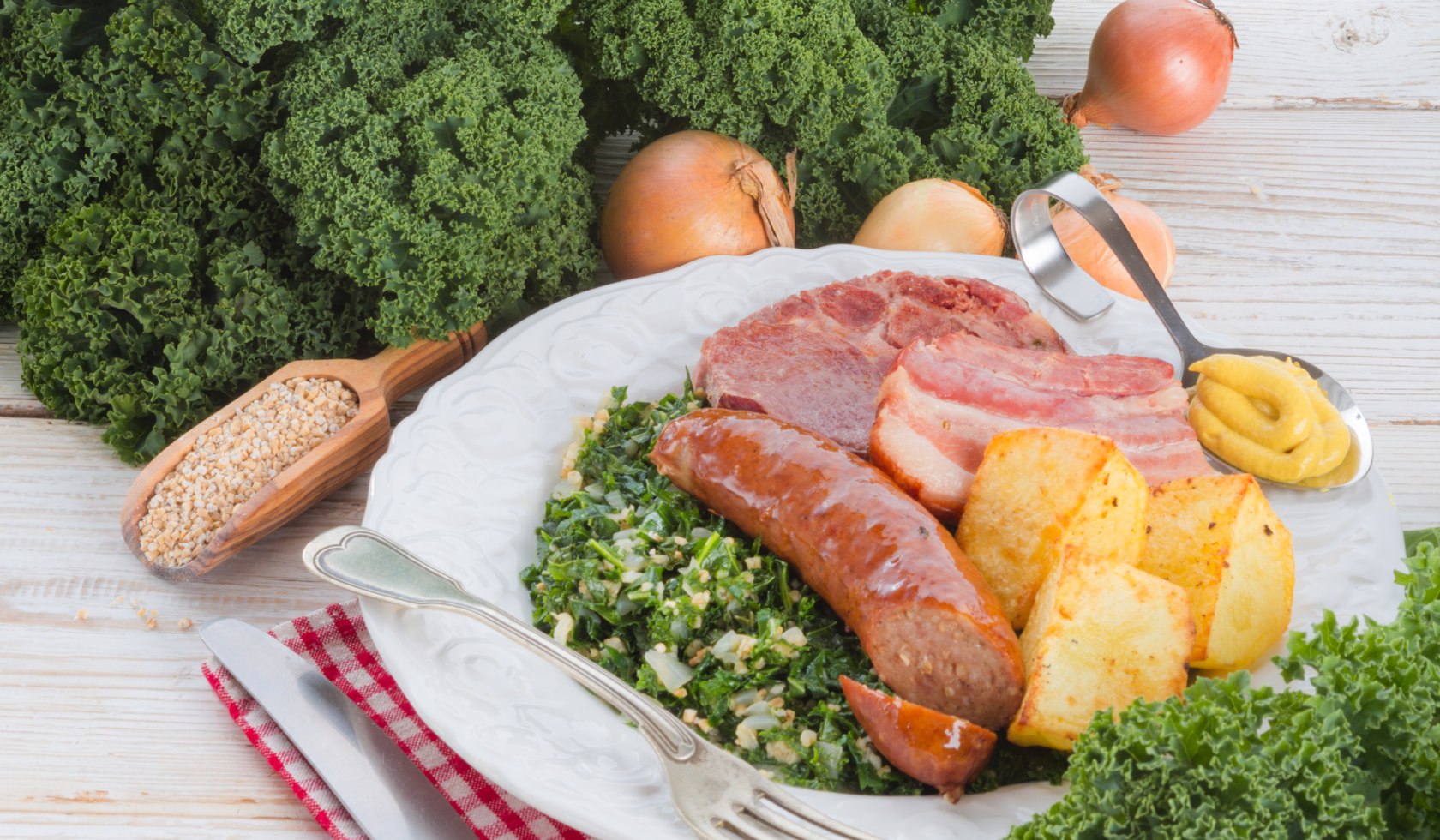 The plate is stocked with kale, pinkel, potatoes and smoked pork., © Fotolia - Dzinnik Darius