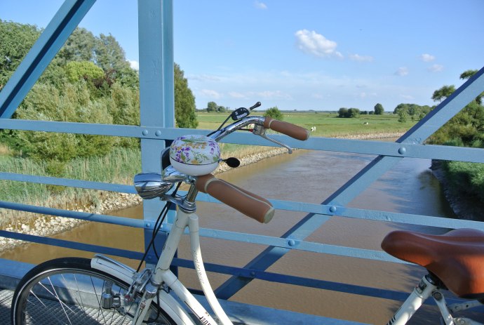 View from the Amdorf bridge in the foreground a bicycle, © Ostfriesland Tourismus GmbH / www.ostfriesland.de