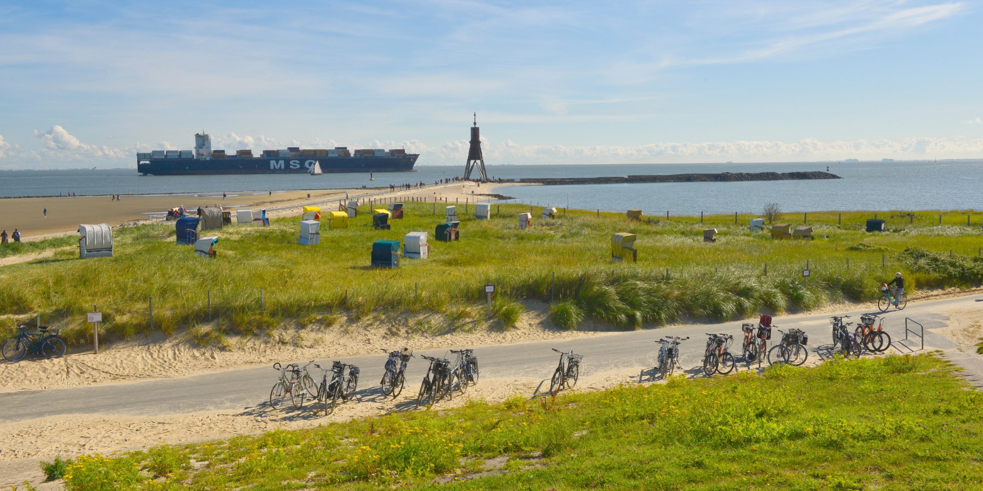 Landscape on the Elbe near Cuxhaven-Döse with Kugelbake, container ship, bicycles and beach chairs., © TMN/Dieter Schinner