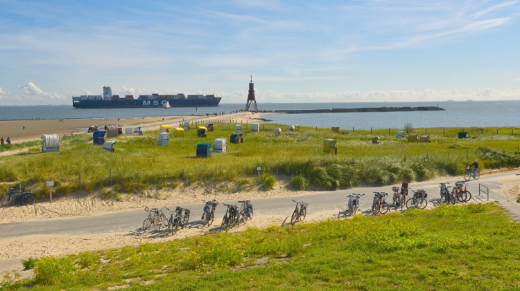 Landscape on the Elbe near Cuxhaven-Döse with Kugelbake, container ship, bicycles and beach chairs., © TMN/Dieter Schinner