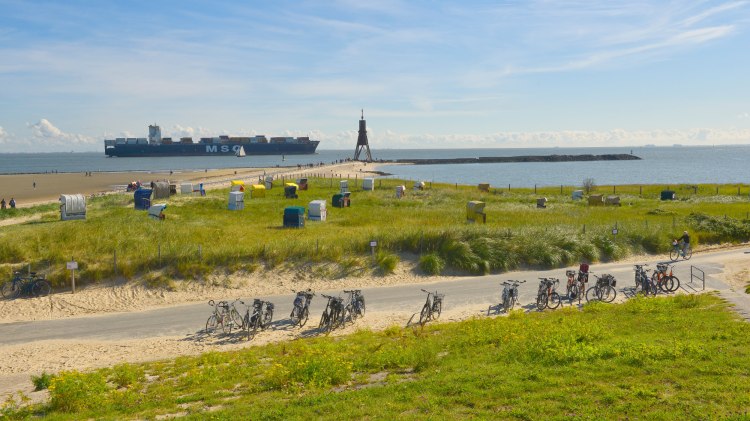 Landscape on the Elbe near Cuxhaven-Döse with Kugelbake, container ship, bicycles and beach chairs., © TMN/Dieter Schinner Landscape on the Elbe near Cuxhaven-Döse with Kugelbake, container ship, bicycles and beach chairs., © TMN/Dieter Schinner