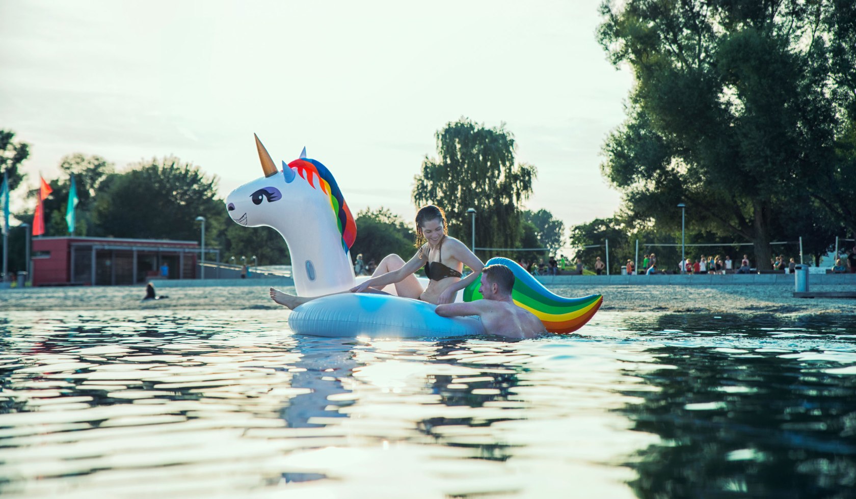 A young woman and a young man bathe in the Allersee with an inflatable unicorn, © Wolfsburg AG / Jenko Sternberg