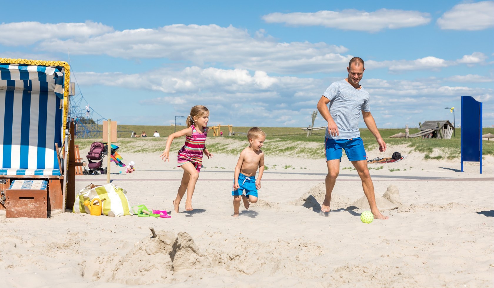 Father with a boy and a girl at the beach playing football, © Center Parcs
