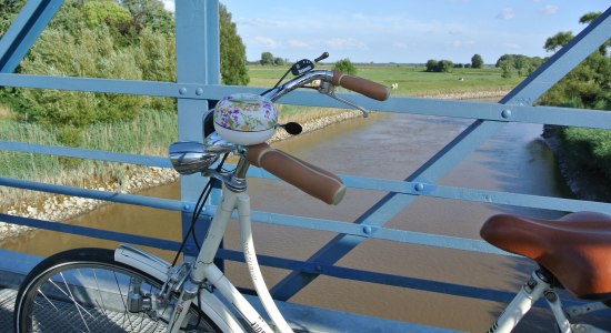 View from the Amdorf bridge in the foreground a bicycle, © Ostfriesland Tourismus GmbH / www.ostfriesland.de