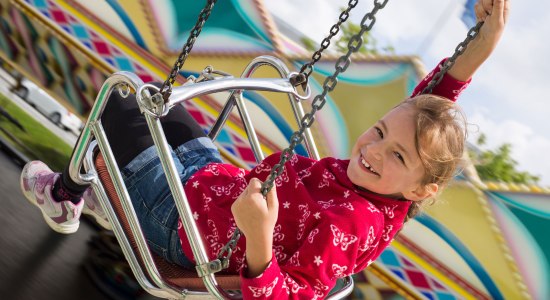 A girl has fun in the chain carousel, © Fotolia / Stefanie B.