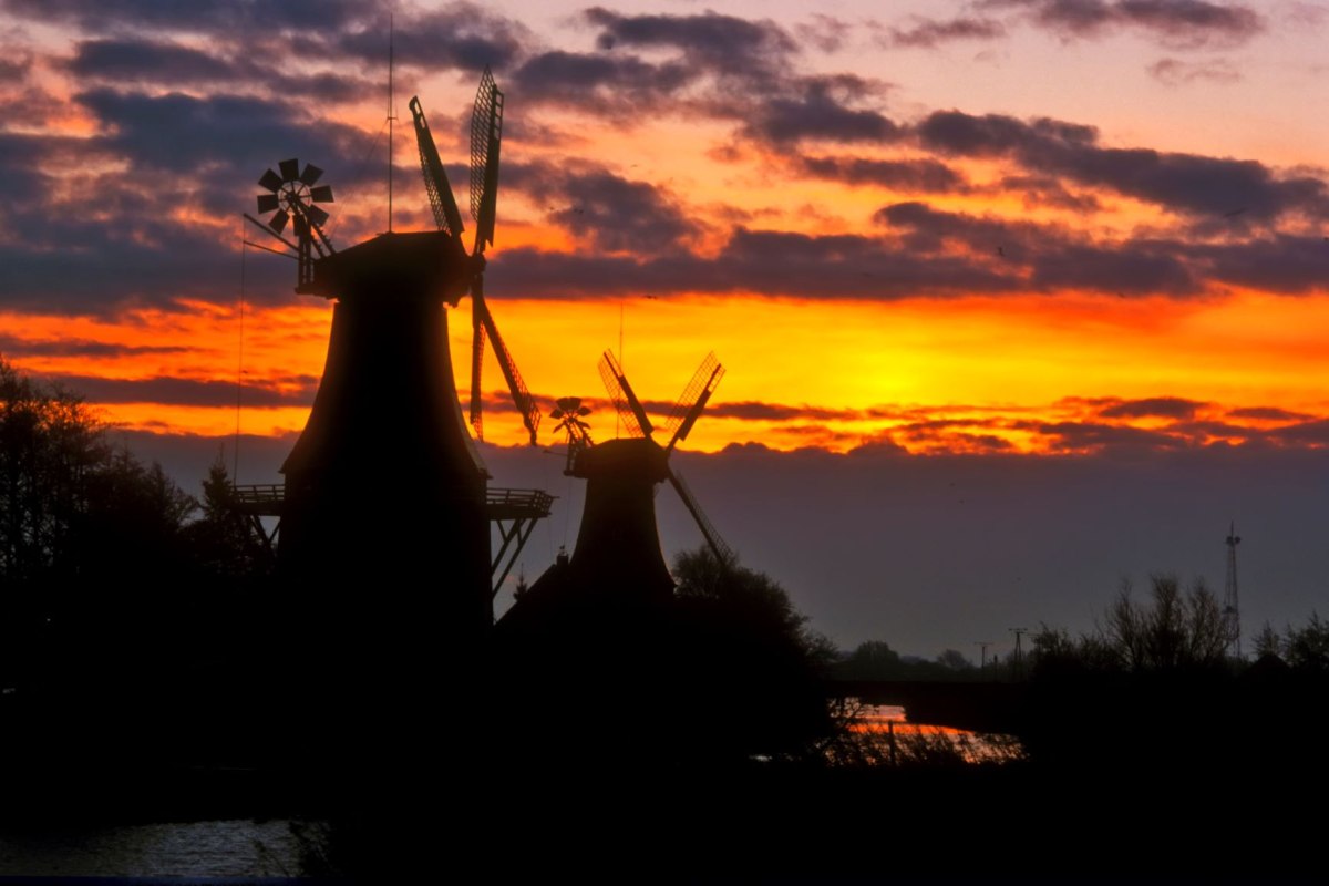 The twin mills of Greetsiel on the old Greetsieler Sieltief are a landmark of the popular place on the North Sea coast, © Dieter Schinner