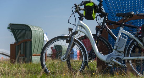 Ebikes lean on a beach chair, © Cuxland-Tourismus / Bernd Otten