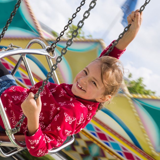 A girl has fun in the chain carousel, © Fotolia / Stefanie B.